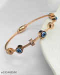 A rose gold wire charm bracelet with evil eye charms and small clear crystal accents, displayed on a white surface.